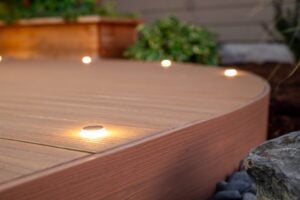 A curved wooden deck edge featuring recessed, glowing warm-white lights.