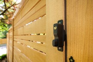 Black metal latch on a horizontal wood slat fence.