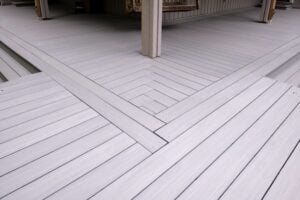 Light gray composite deck planks laid in a chevron pattern.