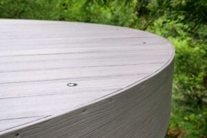 A curved, light gray composite deck edge with small metal lights embedded in the surface.