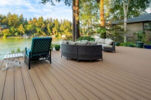 A wooden deck with patio furniture overlooking a lake surrounded by trees.