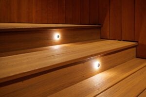 Two wooden steps with small recessed circular lights illuminating the treads.
