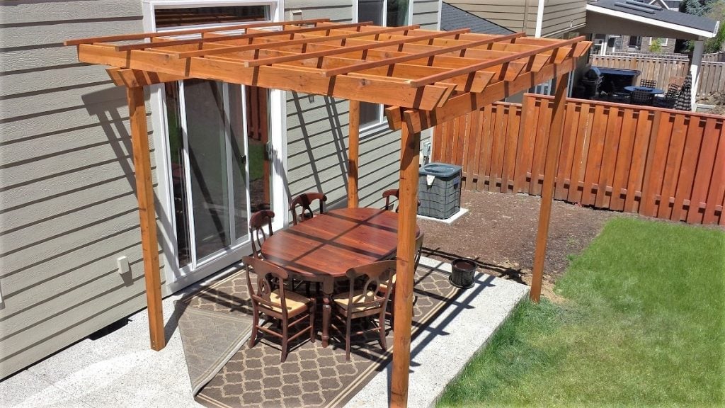 A cedar pergola creates a defined sense of space for this outdoor dining area