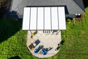 Aerial view of a patio with a rectangular white canopy, patio furniture, and potted plants.