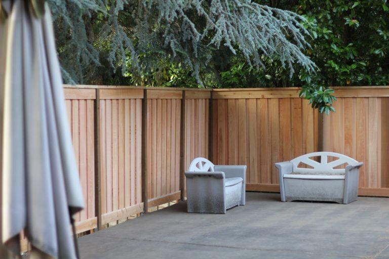 A board-on-board cedar fence creates a private seating area