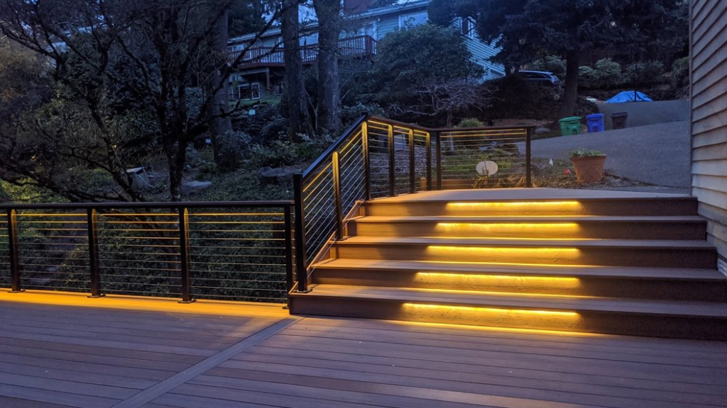 An outdoor deck area with lights and cable railing 