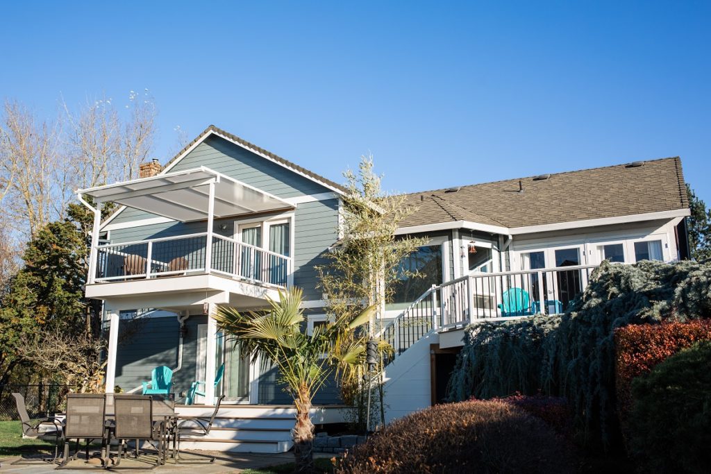 Multi-level deck with railing and patio cover