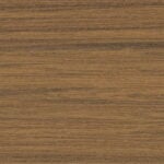 Close-up view of a wooden surface with a natural brown color and horizontal wood grain patterns in various shades of brown. The texture appears smooth with subtle variations in tone.