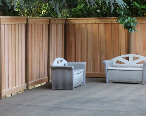 A board-on-board cedar fence creates a private seating area